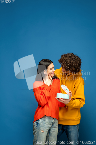 Image of Beautiful couple in love on blue studio background. Valentine\'s Day, love and emotions concept