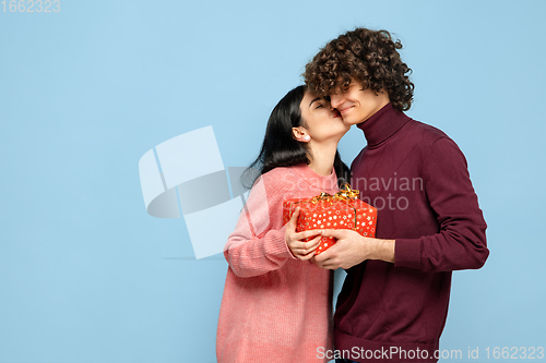 Image of Beautiful couple in love on blue studio background. Valentine\'s Day, love and emotions concept