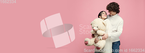 Image of Young, beautiful couple in love on pink studio background. Valentine\'s Day, love and emotions concept