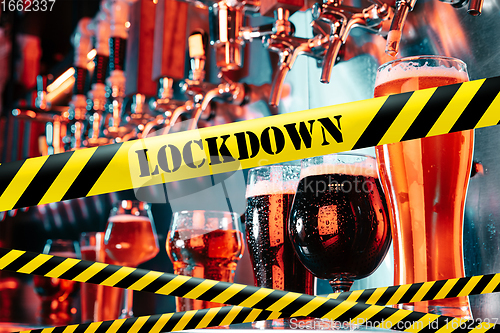 Image of Glasses of different types of beer at bar with bounding tapes Lockdown, Coronavirus, Quarantine, Warning - closing bars and nightclubs during pandemic