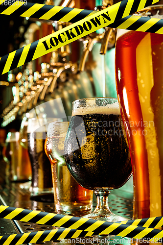 Image of Glasses of different types of beer at bar with bounding tapes Lockdown, Coronavirus, Quarantine, Warning - closing bars and nightclubs during pandemic