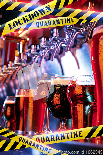 Image of Glasses of different types of beer at bar with bounding tapes Lockdown, Coronavirus, Quarantine, Warning - closing bars and nightclubs during pandemic