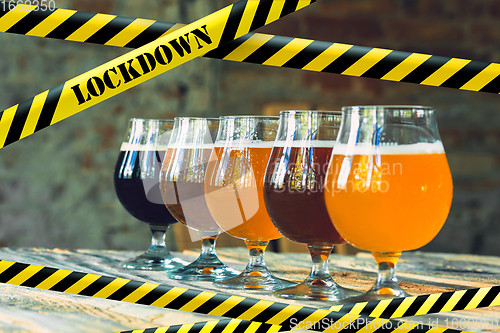 Image of Glasses of different types of beer at bar with bounding tapes Lockdown, Coronavirus, Quarantine, Warning - closing bars and nightclubs during pandemic