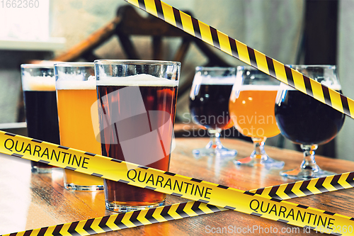 Image of Glasses of different types of beer at bar with bounding tapes Lockdown, Coronavirus, Quarantine, Warning - closing bars and nightclubs during pandemic