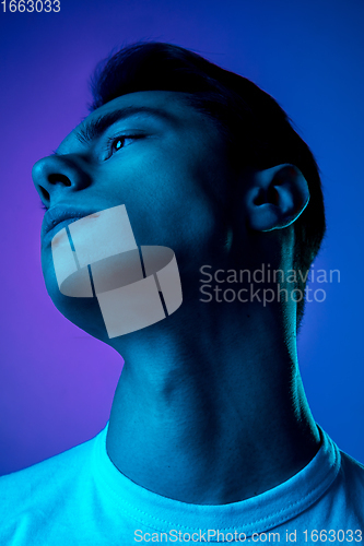 Image of Handsome caucasian man\'s portrait isolated on purple studio background in neon light, monochrome