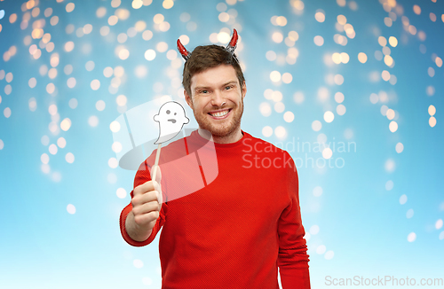 Image of happy man in halloween costume of devil over grey