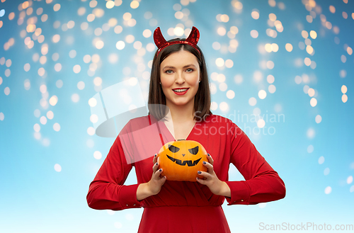 Image of woman in halloween costume of devil with pumpkin