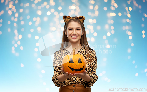 Image of woman in halloween costume of leopard with pumpkin