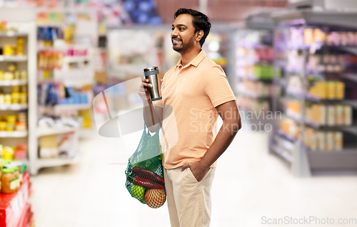 Image of man with food in bag and tumbler or thermo cup