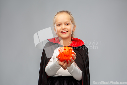 Image of girl in halloween costume of dracula with pumpkin