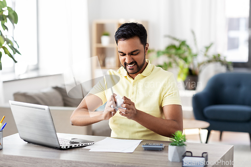 Image of angry man with laptop working at home office