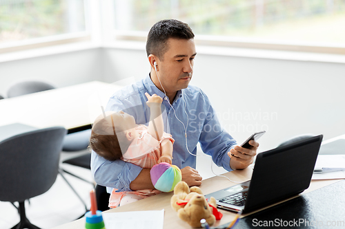 Image of father with baby working at home office