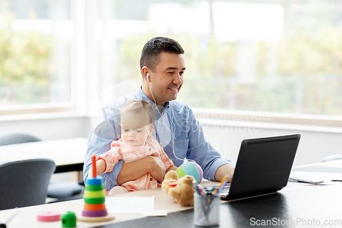 Image of father with baby working at home office