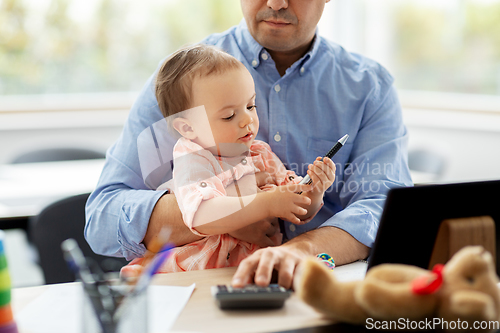 Image of father with baby working at home