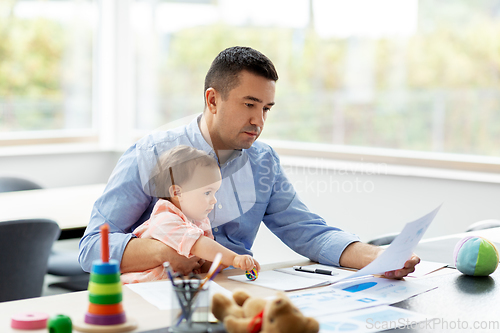 Image of father with baby working at home office