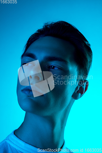 Image of Handsome caucasian man\'s portrait isolated on blue studio background in neon light, monochrome