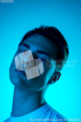 Image of Handsome caucasian man\'s portrait isolated on blue studio background in neon light, monochrome