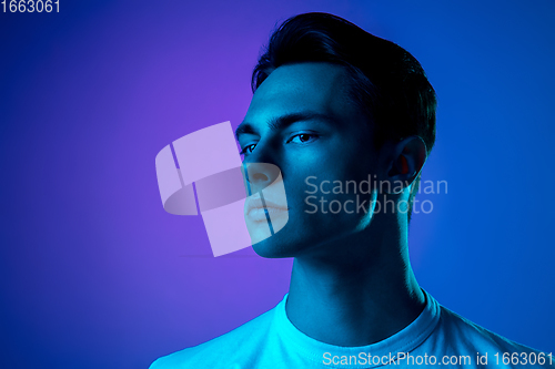 Image of Handsome caucasian man\'s portrait isolated on purple studio background in neon light, monochrome