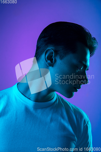 Image of Handsome caucasian man\'s portrait isolated on purple studio background in neon light, monochrome