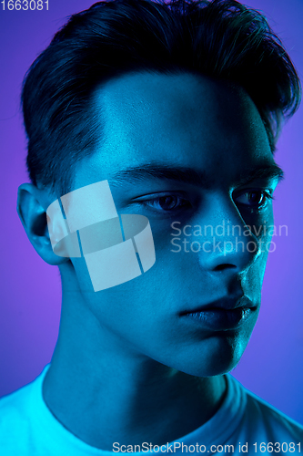 Image of Handsome caucasian man\'s portrait isolated on purple studio background in neon light, monochrome