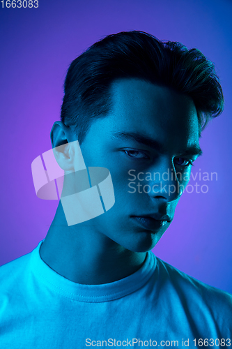 Image of Handsome caucasian man\'s portrait isolated on purple studio background in neon light, monochrome