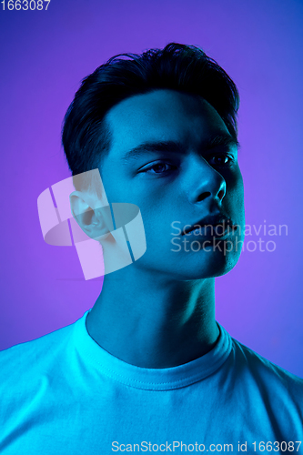 Image of Handsome caucasian man\'s portrait isolated on purple studio background in neon light, monochrome