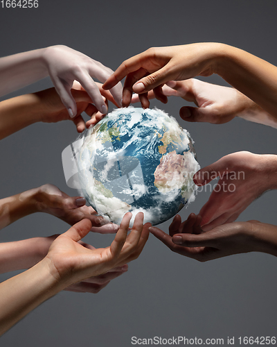 Image of Hands holding planet Earth, close up on grey background. Environment save, taking care of nature and ecology, supporting hands concept