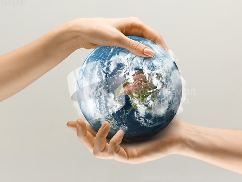 Image of Hands holding planet Earth, close up. Environment save, taking care of nature and ecology, supporting hands concept