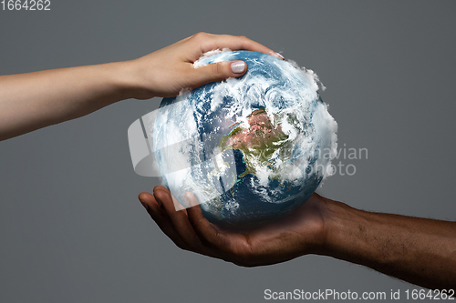 Image of Two hands holding planet Earth, close up. Environment save, taking care of nature and ecology, supporting hands concept