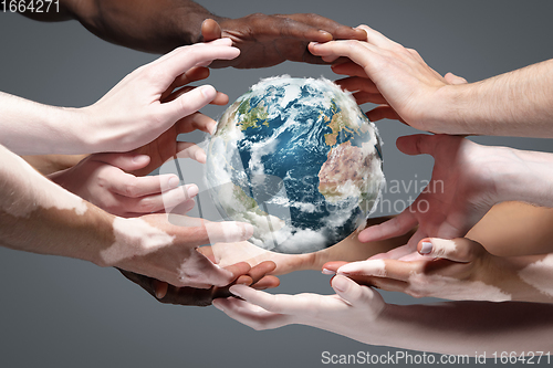 Image of Hands holding planet Earth, close up on grey background. Environment save, taking care of nature and ecology, supporting hands concept