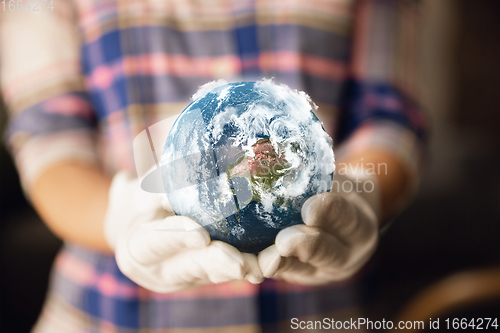 Image of Hands holding planet Earth, close up. Environment save, taking care of nature and ecology, supporting hands concept