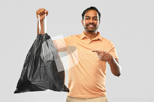 Image of smiling indian man holding trash bag