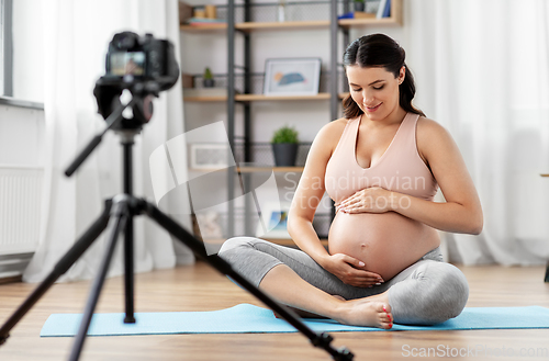 Image of happy pregnant woman blogger recording yoga video