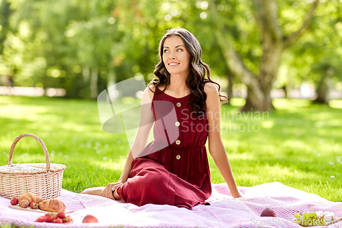 Image of happy woman with picnic basket at summer park