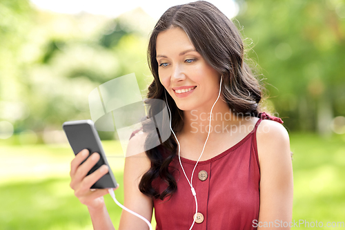 Image of woman with smartphone and earphones at park