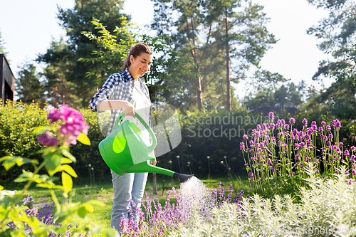 Image of young woman watering flowers at garden