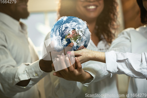 Image of Doctors holding a world globe in hands, concept of world health, supporting