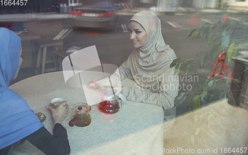 Image of Beautiful arab women meeting at cafe or restaurant, friends or business meeting