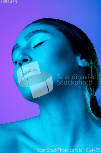 Image of Beautiful east woman portrait isolated on gradient studio background in neon light, monochrome