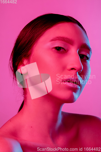 Image of Beautiful east woman portrait isolated on pink studio background in neon light, monochrome