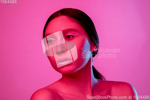 Image of Beautiful east woman portrait isolated on pink studio background in neon light, monochrome