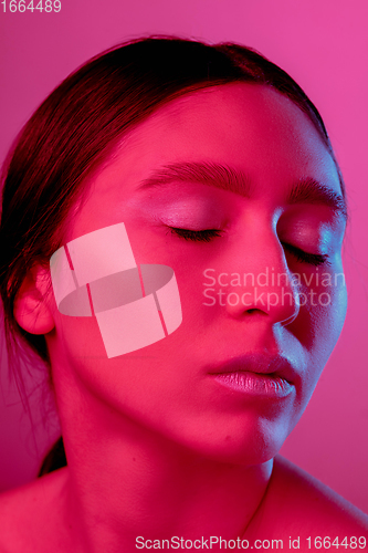 Image of Beautiful east woman portrait isolated on pink studio background in neon light, monochrome