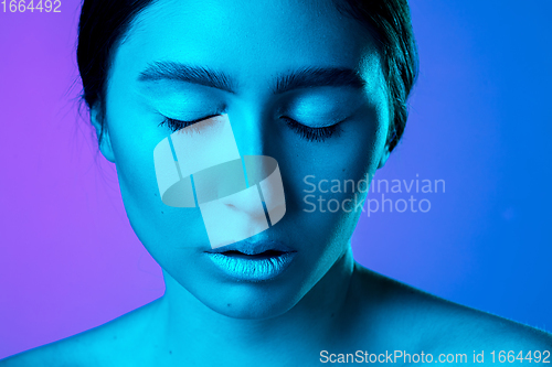 Image of Beautiful east woman portrait isolated on gradient studio background in neon light, monochrome