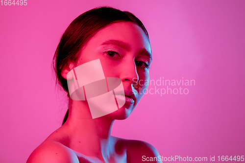 Image of Beautiful east woman portrait isolated on pink studio background in neon light, monochrome