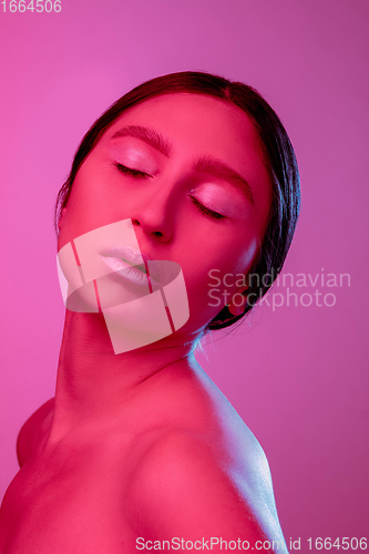 Image of Beautiful east woman portrait isolated on pink studio background in neon light, monochrome