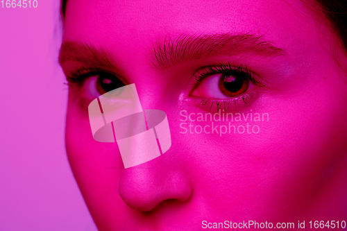 Image of Beautiful east woman portrait isolated on pink studio background in neon light, monochrome
