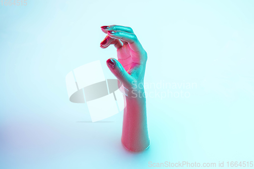 Image of Close up female hand gesturing from the milk bath with soft glowing in neon light