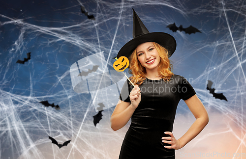 Image of woman in halloween costume of witch with pumpkin