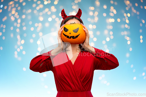 Image of woman in halloween costume of devil with pumpkin