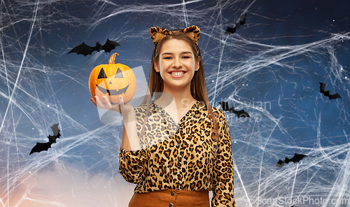 Image of woman in halloween costume of leopard with pumpkin